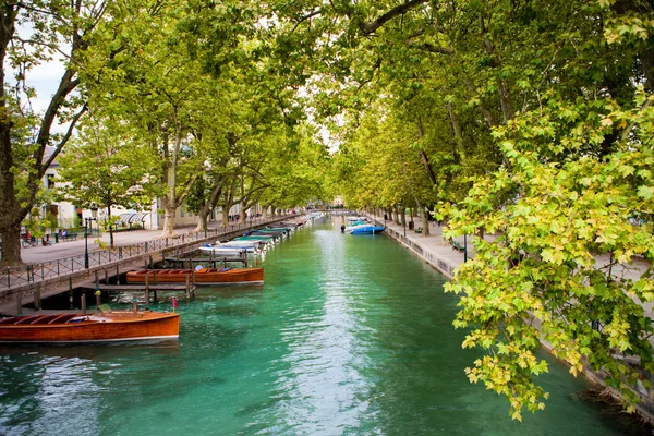 Canal arboré d'Annecy, bateaux en bois et eau turquoise